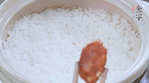 煮開后轉小火，當米飯出現小孔時，鋪上金字麻辣香腸。